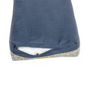 Pillow-type blue and yellow geometric patterned bed with a bee details and a blue underside pictured pictured upside down on a white background with the zip partially open. 