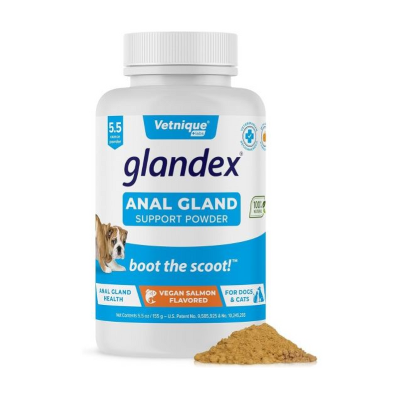 White background with a blue and white tub of Glandex Anal Gland Support Powder. On the tub is a picture of a bull dog with its bottom pointed forwards. Additional text states 'Boot the scoot!' and 'Anal gland health, Vegan Salmon Flavoured, for cats and dogs.' In the foreground is a small pile of the powder. 
