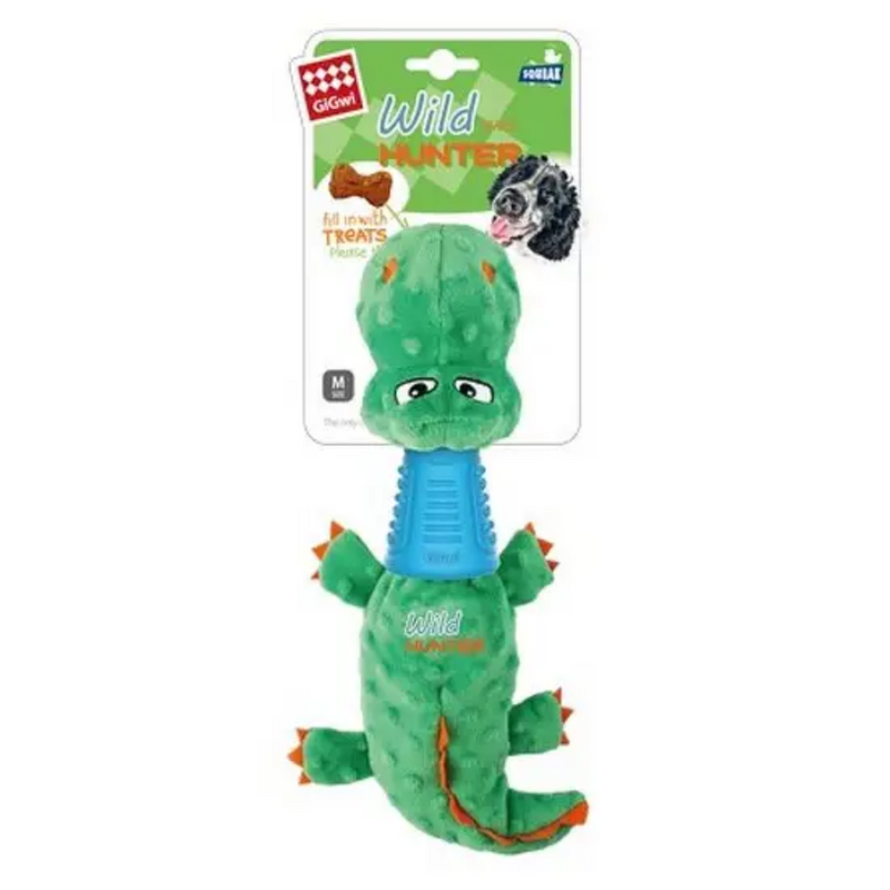 Green crocodile plush dog toy with blue rudder neck and orange spines and claws, backed onto cardboard packaging that has as picture of a black and white Spaniel and a picture of s bone shaped dog treat with an arrow which says 'fill with treats' 