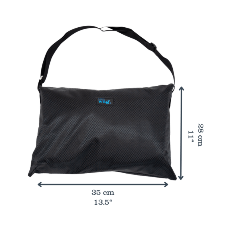 Henry Wag Easy-roll travel bed in it's black carry bag, with measurements on either side indicting width 35cm, height 28cm. Pictured on a white background. 
