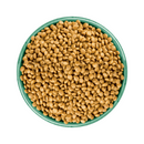 White background with a green bowl pictured filled with cat food kibbles. 