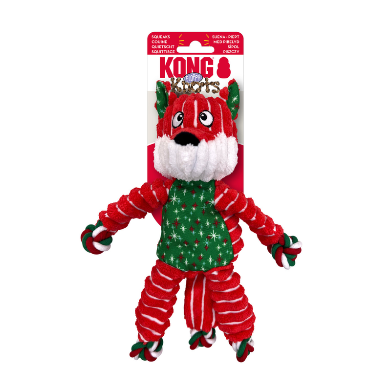 Red, green and white stripy fabric and rope Fox Dog Toy with snowflake and star fabric ears and belly attached to a cardboard backing, pictured on a white background. 