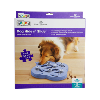 Box packaging for a Nina Ottosson Dog Hide n' Slide toy, featuring a dog on the front of the box looking at the blue puzzle toy.
