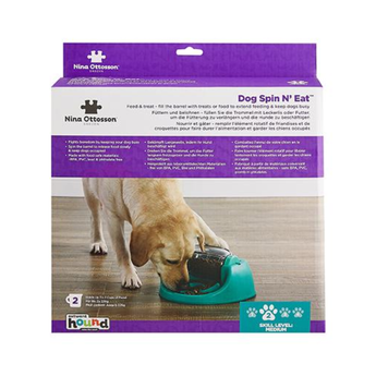 Nina Ottosson Dog Spin N' Eat dog puzzle feeder in its retail packaging, featuring a picture of a golden retriever eating from a teal bowl.