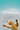 An orange tabby cat stretches upward with its paws extended against a white fence and turquoise sky background, with the text 'GET YOUR PAWS ON A BARGAIN' overlaid across the center.