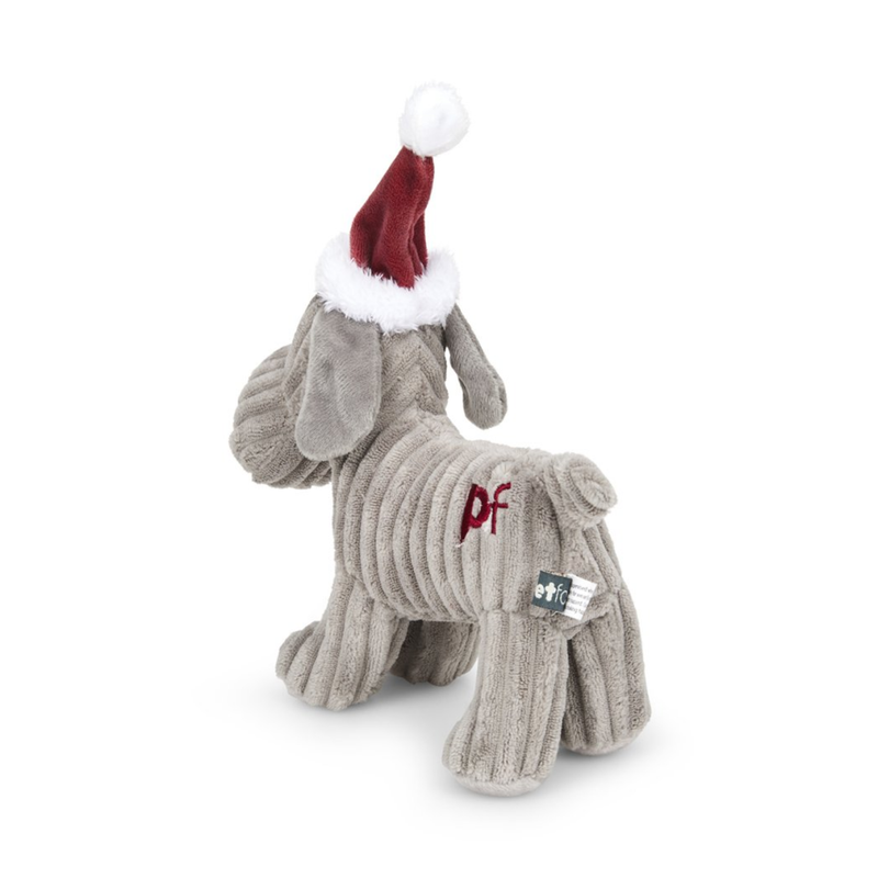 Back view of grey dog dog toy made from soft cord effect fleece material with red 'PF' stitched on hip, wearing a red Christmas hat, standing on a white background. 