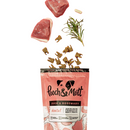 White background with an open orange packet of Pooch & Mutt dog treats, treats are spilling out from the packet along with a sprig of rosemary and duck chunks. 