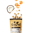 White background with an open peach coloured packet of Pooch & Mutt dog treats, treats are spilling out from the packet along with a quarter of a coconut and some shrimp. 