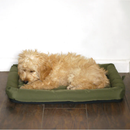 Young cockerpoo dog sat on a Water Resistant green dog crate mattress on a hardwood floor. 