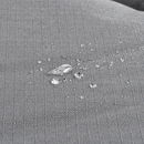 Close up of a Bolster-type grey dog bed with water droplets pictured on the waterproof surface. 