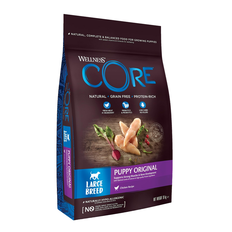 White background with a picture of a bag of Wellness CORE Original Puppy Food. On the bag is pictures of chicken fillets, peas, cranberries and a beet. The text on the bag 'Wellness CORE, Natural, Grain Free, Protein-Rich' and 'Large breed, Puppy Original, Chicken Recipe'. 