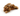 Brown rabbit dog toy with stitch eye details lying on a white background. 