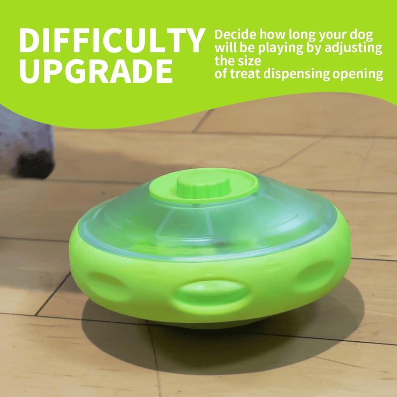 UFO shaped treat dispenser with green central and top parts with main body in grey on a laminate floor. A bright green banner with white text say 'Difficulty Upgrade. Decide how long your dog will be playing by adjusting the size of the treat dispensing opening.' 