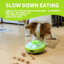 Brown and white collie-type dog playing with the UFO shaped treat dispenser with green central and top parts with main body in grey on a laminated floor. A bright green banner with white text say Slow down eating. Simply fill the ufo with dog's favourite snacks. The smell of treats drives your dog to roll.' 