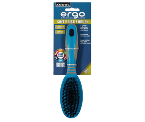 White background with a small blue and grey Ergo Soft Bristle Brush for dogs attached to a cardboard packaging. 