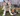 A cream-coloured collie cross with an Ancol plush leopard dog toy lying next to it's paws in a garden setting.