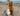 Pomeranian dog sat next to a Ancol Made From Seagull dog toy on a beach with St.Micheals Mount in the background. 