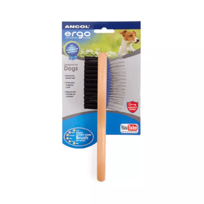 White background with a side on view of a small wooden handled Ergo Double-sided Brush for dogs, showing both a metal bristle side and a soft bristle side attached to cardboard packaging.