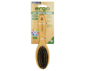 White background with a wooden Ergo Soft Bristle Brush for small dogs, puppies and cats attached to a cardboard packaging. 