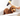 Brown poodle type dog in a bath tub,  with a hand holding a bottle of Animology Curly Coat Shampoo above the dog's back. 