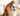 Brown poodle type dog on a cream sofa, with a someone holding a black and blue spray bottle of Animology Mucky Pup no rinse shampoo. 
