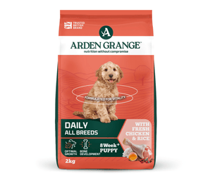 A 2kg bag of Arden Grange, Daily, All Breeds 8 Week Puppy dog food, featuring a red and green bag with a picture of a golden doodle on the front.