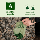 Person holding a Beco brand poop bag with text about a four-months supply on a pebbly background
