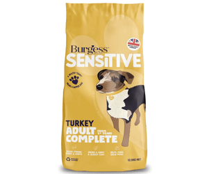White background with a yellow bag of Burgess Sensitive Adult dry food. On the bag is a illustration of a tri-coloured dog. Text on the bag reads 'Burgess Sensitive, Turkey Adult Complete, from 1+ years'. 
