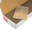 Close up of corrugated cardboard scratched inside it's outer box with the lid open with a packet of catnip on top. 