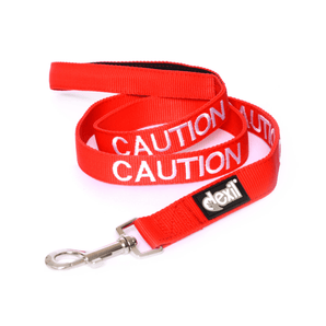 White background with a red Dexil lead with the word 'caution' stitched in white.