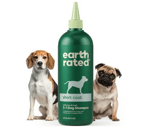 White background with a green bottle of Earth Rated Short Coat Dog Shampoo, additionally on the bottle is text 'White tea & basil, 3 in 1 Dog Shampoo'. A beagle is pictured on the left and a pug is on the right of the bottle. 
