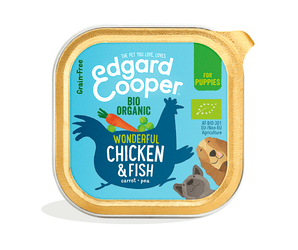 White background with a tray of Edgard and Cooper wet puppy food pictured. Text on the foil of the tray says 'Bio Organic, wonderful chicken & fish, carrot, pea.' 