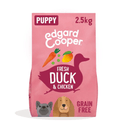 White background with an pink bag of Edgard & Cooper Puppy Dry Food Duck and Chicken pictured. On the packet is an illustrated French Bulldog and Cocker Spaniel puppy. Text on the pack reads, 'Edgard & Cooper.' A silhouette of a duck has text inside 'Fresh Duck and Chicken'.