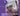 Cat being held with a hand on a purple background, text about feline stress expertise and calming for cats and kittens.