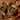 A styled flat-lay of a Forthglade fish wet dog food ingredient blend on a rustic wooden table, featuring cubed brown meat pieces in a bowl, a bowl of brown rice, a whole fish, carrots, peas, and other ingredients with text overlays reading 'brown rice', 'wholesome veg' and '75% fish'.