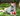 A brown and white collie cross dog laying on a grass with a apple-shaped Happy Pet Very Hungry Caterpillar tugger dog toy.