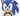 A close up of a jumbo plush dog toy of Sonic the Hedgehog, featuring his classic blue and beige colour scheme with green eyes, shown against a plain white background.
