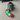 A grey dog laying on a beige carpet playing with a colourful Happy Pet Very Hungry Caterpillar plush dog toy.