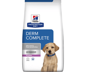 Hills Prescription Diet Derm Complete dry puppy food packaged in a white bag with a golden Labrador puppy pictured on the bag. Text on bag says 'Hill's Prescription Diet, Derm Complete' and 'Skin Care & Food Sensitivities, Veterinarian recommended, Puppy' pictured on white background. 