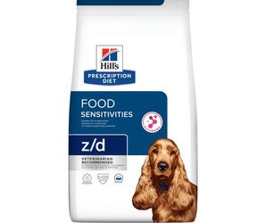 Hills Prescription Diet Food Sensitivities dry dog food packaged in a white bag with an adult brown Cocker Spaniel pictured on the bag. Text on bag says 'Hill's Prescription Diet, Food Sensitivities' and 'Z/D, Veterinarian recommended' pictured on white background. 