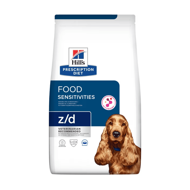 Hills Prescription Diet Food Sensitivities dry dog food packaged in a white bag with an adult brown Cocker Spaniel pictured on the bag. Text on bag says 'Hill's Prescription Diet, Food Sensitivities' and 'Z/D, Veterinarian recommended' pictured on white background. 