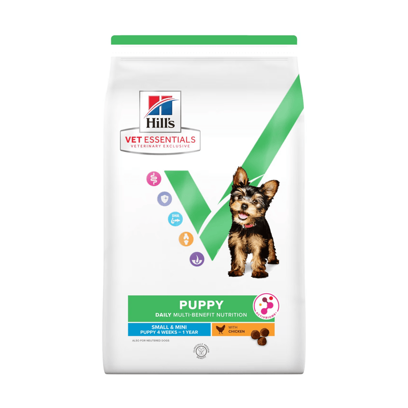 Hills Vet Essentials dry puppy food packaged in a white bag with a Yorkshire Terrier puppy pictured on the bag. Text on bag says 'Hill's Vet Essentials, veterinary exclusive' and 'Puppy, Small and Mini, 4 weeks - 1year' with a chicken pictured with text 'with Chicken' beneath on white background. 