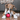 Brown and white boxer puppy playing with a KONG Classic ball in a living room environment. 