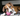 Brown and white boxer puppy playing with a pink KONG Puppy Activity ball in a living room environment. 