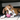 Brown and white boxer puppy playing with a pink KONG Puppy Activity ball in a living room environment. 