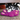 Black and white husky puppy playing with a KONG Snuzzles Bunny dog toy, the main body is made from purple fur body with pink feet and inner ears with stitched features. 