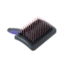 White background with a large black plastic brush with purple grip handle and plastic bristles with red tips facing up pictured. 