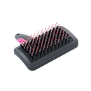 White background with a medium black plastic brush with pink grip handle and plastic bristles with red tips facing up pictured. 