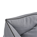 Close up of corner of a grey dog bed with black trimming. 