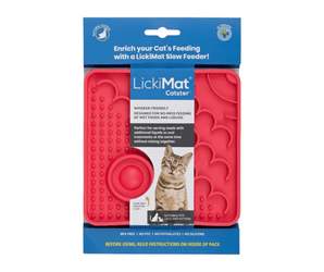 White background with a red square LickiMat Catster slow feeder mat with a scaly and bobbly surface. The Catster mat is in blue and white cardboard packaging with a cat pictured on the packet. 
